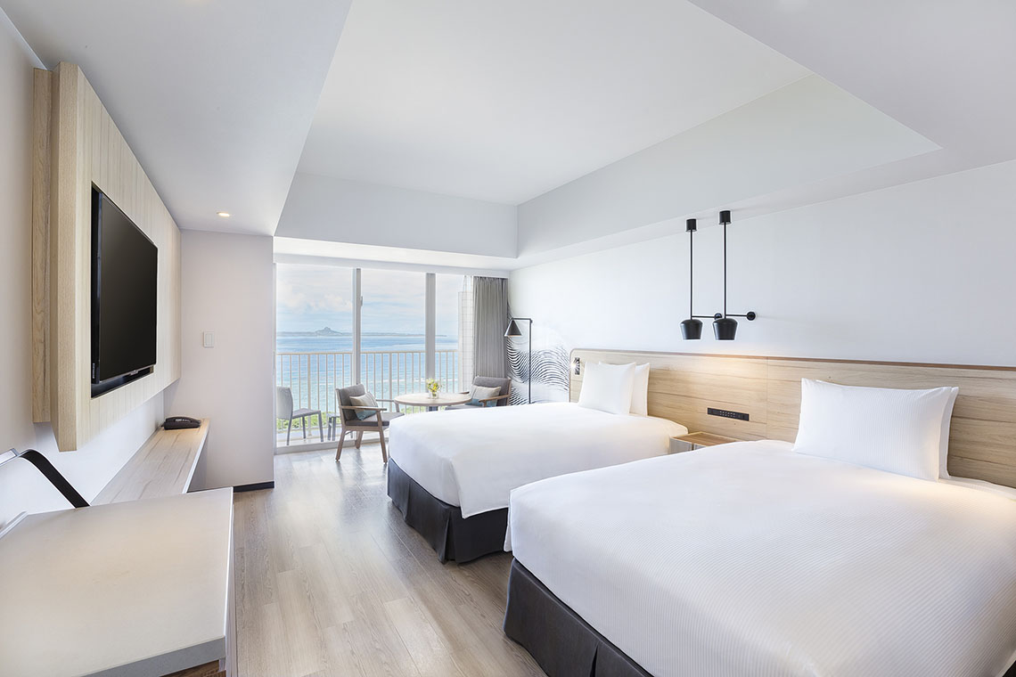 a twin guest room with a view of the sea